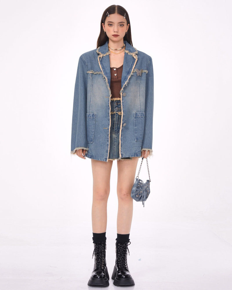 A distressed denim blazer featuring a charming butterfly pin and frayed edges. This jacket includes large front pockets and a lapel collar, perfect for adding a vintage and grunge touch to any outfit