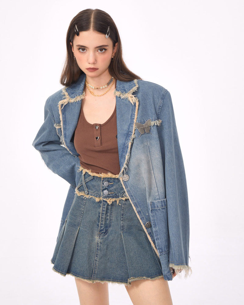 A distressed denim blazer featuring a charming butterfly pin and frayed edges. This jacket includes large front pockets and a lapel collar, perfect for adding a vintage and grunge touch to any outfit