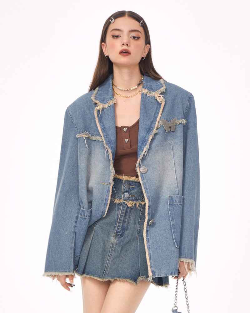 A distressed denim blazer featuring a charming butterfly pin and frayed edges. This jacket includes large front pockets and a lapel collar, perfect for adding a vintage and grunge touch to any outfit