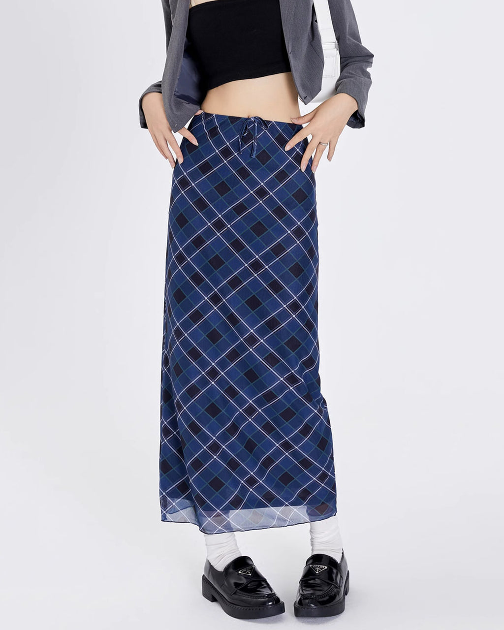 A stylish blue plaid maxi skirt with a high-waist design and drawstring closure. The skirt features a checkered pattern in varying shades of blue, creating a modern yet classic look. Its long, straight silhouette provides a sleek and elegant appearance, perfect for both casual and semi-formal occasions