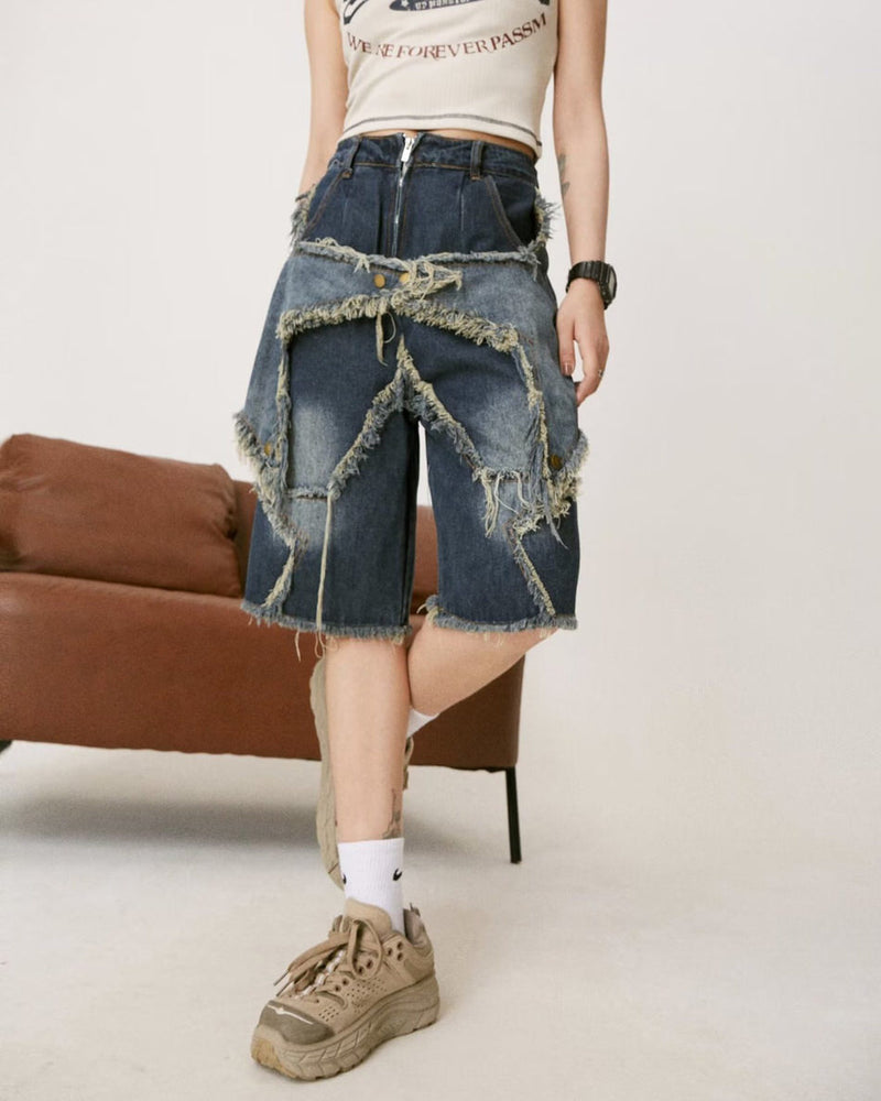 Dark wash denim shorts featuring a unique star-shaped distressed design with frayed edges. These high-waisted shorts blend a classic style with an edgy aesthetic