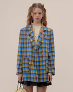 The Oversized Preppy-Style Plaid Blazer features a vibrant blue and yellow plaid pattern. Its double-breasted style and roomy fit make it ideal for layering over any look