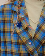 The Oversized Preppy-Style Plaid Blazer features a vibrant blue and yellow plaid pattern. Its double-breasted style and roomy fit make it ideal for layering over any look