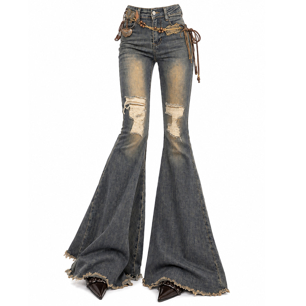 Distressed flare jeans in faded blue denim with ripped knees, frayed hems